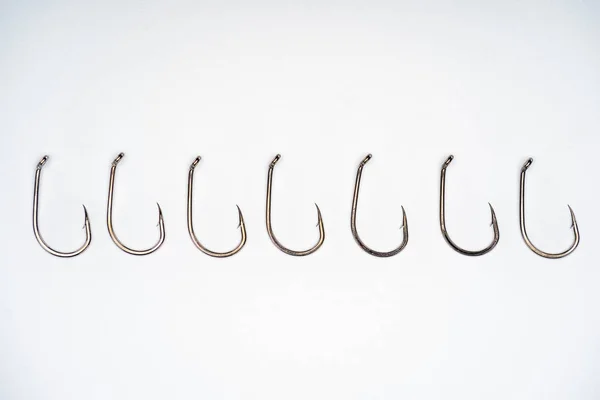 Top view of fishing hooks placed in row isolated on white — Stock Photo