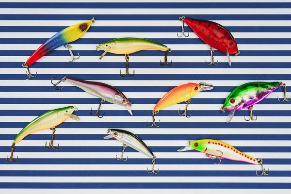 Elevated view of various fishing bait on striped background — Stock Photo