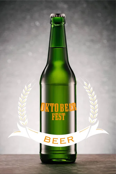 Beer bottle on tabletop on grey background with 