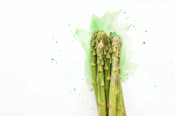 Vue du dessus du bouquet d'asperges mûres sur une surface blanche avec des traits d'aquarelle verts — Photo de stock