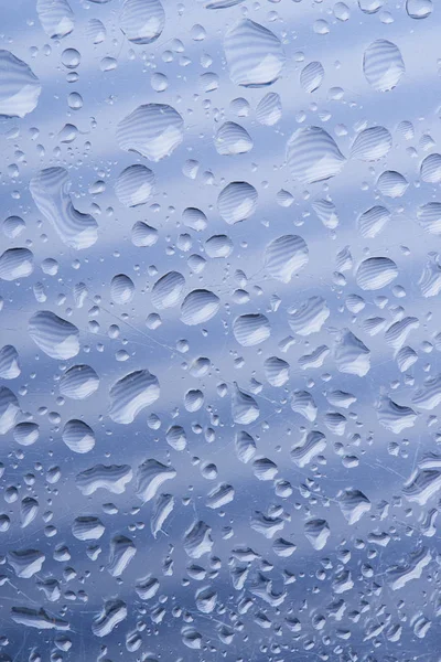 Vista de cerca de hermosas gotas de agua transparentes tranquilas sobre fondo abstracto gris - foto de stock