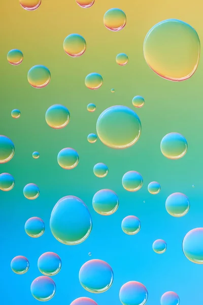 Vue rapprochée de belles gouttes d'eau transparentes et calmes sur fond abstrait coloré — Photo de stock