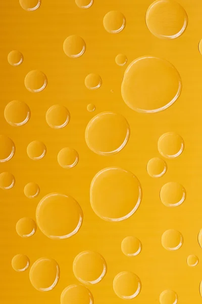 Belles gouttes d'eau calme et propre sur fond jaune vif — Photo de stock