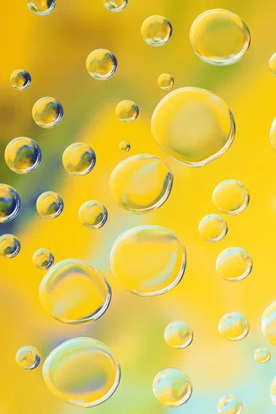 Bela calma gotas de água limpa no fundo abstrato amarelo — Fotografia de Stock