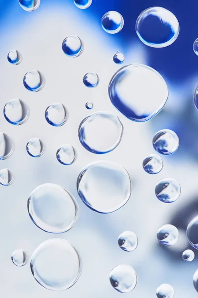 Beautiful transparent water drops on blurred abstract background — Stock Photo