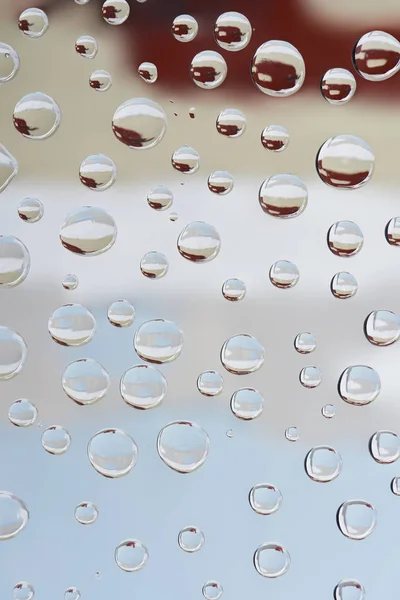 Vista close-up de belas gotas de orvalho transparente sobre fundo abstrato borrado — Fotografia de Stock