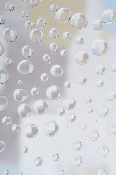 Vista close-up de belas gotas de chuva transparentes sobre fundo abstrato borrado — Fotografia de Stock