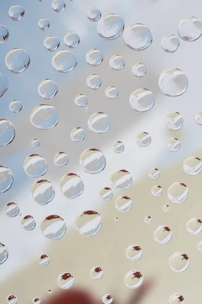 Vista de cerca de gotas de agua transparentes sobre fondo abstracto borroso - foto de stock