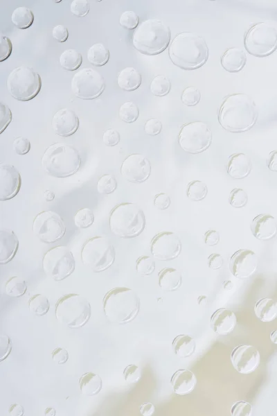 Vista de cerca de gotas de agua transparentes sobre fondo abstracto de luz - foto de stock