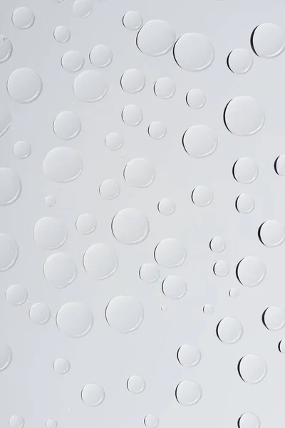 Vista de cerca de gotas de agua transparentes sobre fondo abstracto gris claro - foto de stock