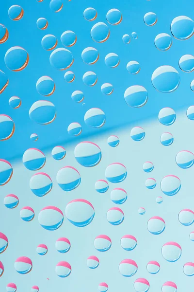 Vista de cerca de gotas de rocío transparente sobre fondo abstracto azul - foto de stock