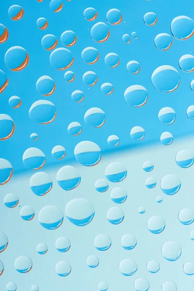 Close-up view of transparent rain drops on blue abstract background — Stock Photo