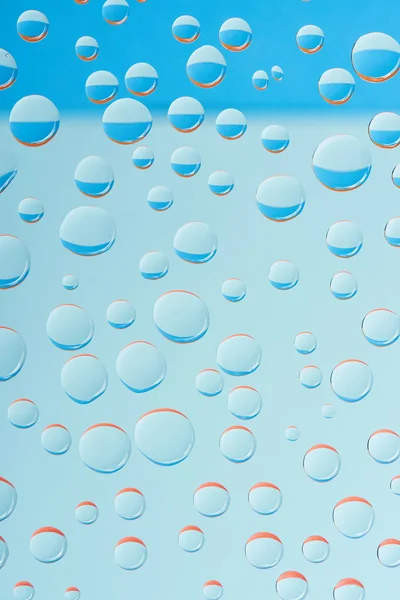 Vue rapprochée de gouttelettes transparentes sur fond bleu clair — Photo de stock
