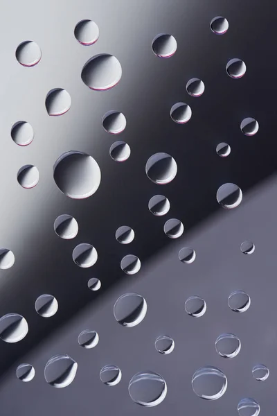 Close-up view of transparent calm dew drops on grey background — Stock Photo