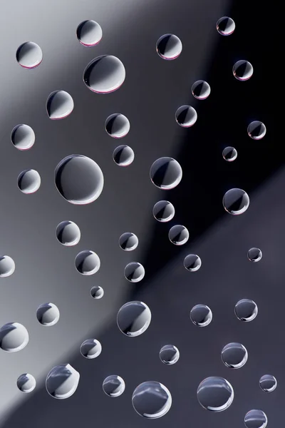 Close-up view of transparent droplets on dark background — Stock Photo