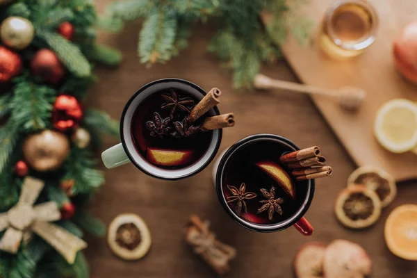 Vista superior de copas de vino caliente con palitos de canela en la mesa de madera, concepto de Navidad - foto de stock