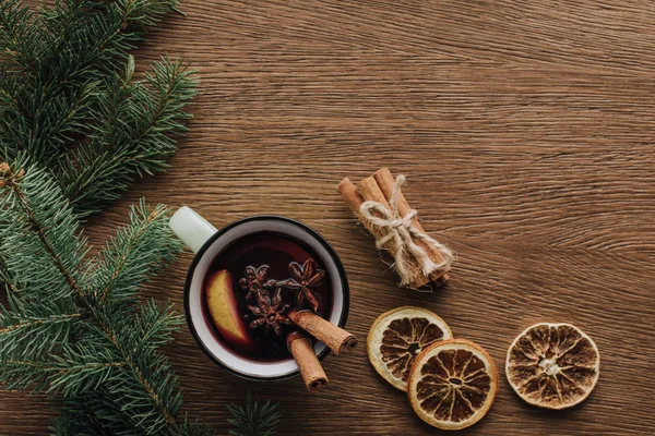 Top view of mulled wine, dried oranges and fir twigs on wooden tabletop, christmas concept — Stock Photo