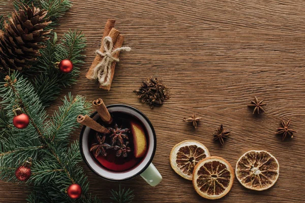 Vista superior de vino caliente, naranjas secas y ramas de abeto con adornos en la mesa de madera, concepto de Navidad — Stock Photo
