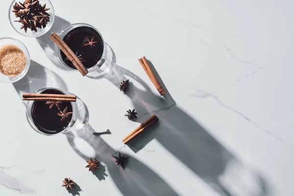 Top view of glasses of mulled wine and carnation on white tabletop — Stock Photo