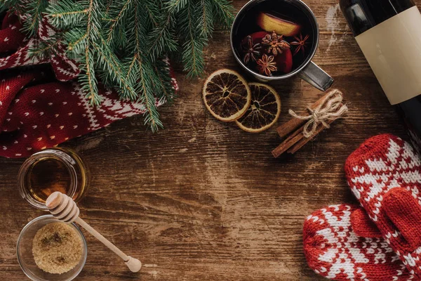 Vue du dessus du vin chaud en tasse et mitaines sur table en bois, concept de Noël — Photo de stock