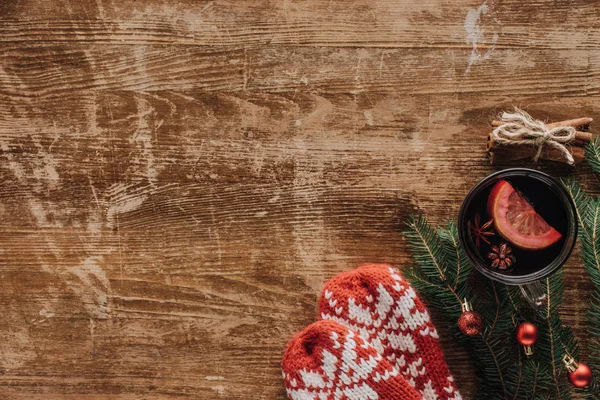 Top view of cup of mulled wine, fir twigs and mittens on wooden tabletop, christmas concept — Stock Photo