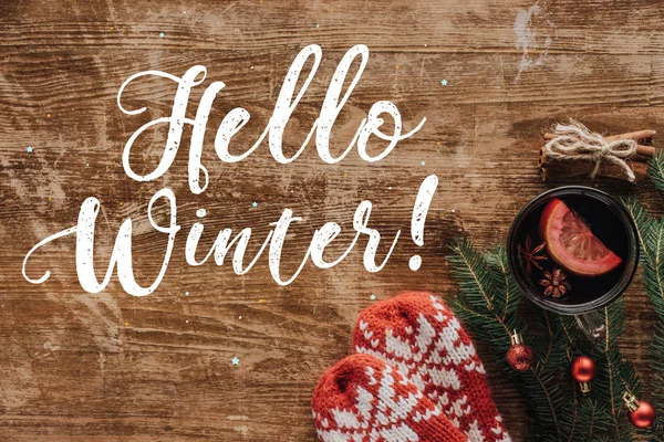 Elevated view of mulled wine in cup and greeting Hello Winter on wooden tabletop, christmas concept — Stock Photo