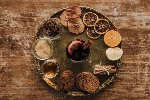 Glühwein in Tasse und Plätzchen auf rundem Tablett auf Holztisch — Stockfoto