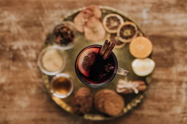 Elevated view of mulled wine in cup and cookies on round tray on wooden table — Stock Photo