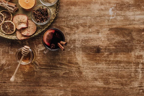 Top view of cup of mulled wine and honey on wooden table — Stock Photo