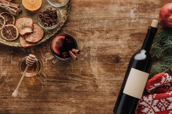 Vista superior da xícara de vinho quente e garrafa de vinho na mesa de madeira, conceito de Natal — Fotografia de Stock