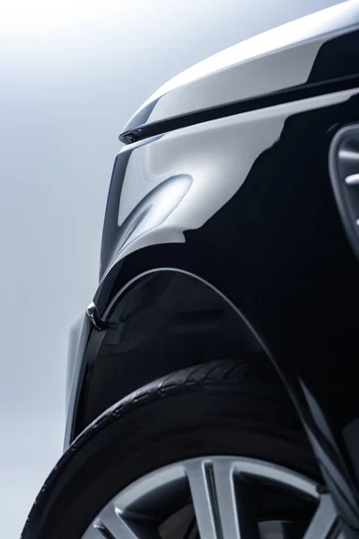 Крупним планом новий чорний автомобіль на сірому фоні — стокове фото