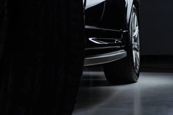 Vue rapprochée luxe brillant noir automobile sur fond sombre — Photo de stock
