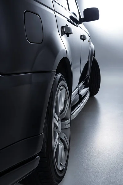 Vista de cerca del coche de lujo negro sobre fondo gris - foto de stock