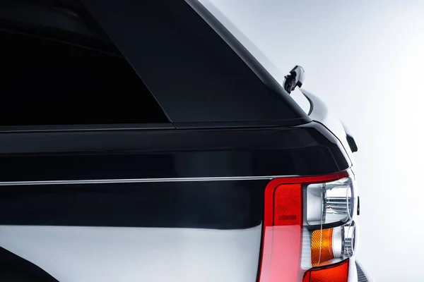 Vista de cerca de las luces delanteras de automóviles de lujo coche negro sobre fondo gris - foto de stock