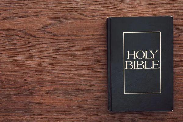 Ansicht der geschlossenen Heiligen Bibel auf hölzerner Oberfläche — Stockfoto