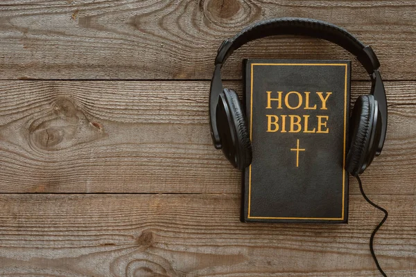 Top view of holy bible with headphones on wooden surface — Stock Photo
