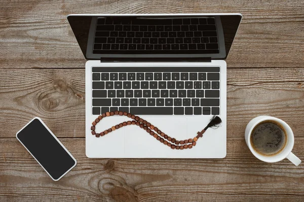 Vista superior de laptop e smartphone com contas e café na mesa de madeira — Fotografia de Stock