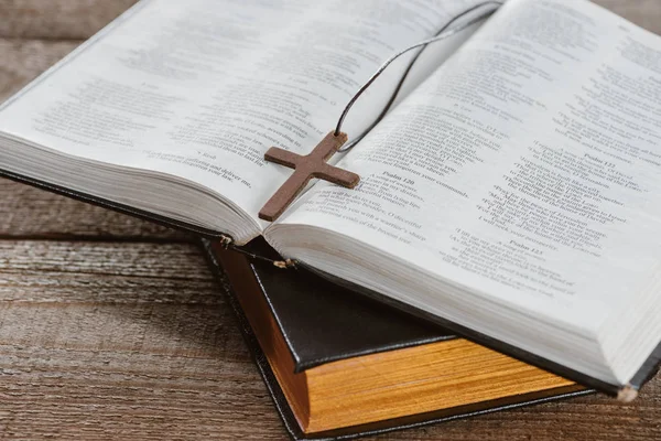 Plan rapproché de bibles sacrées avec croix sur une table en bois — Photo de stock
