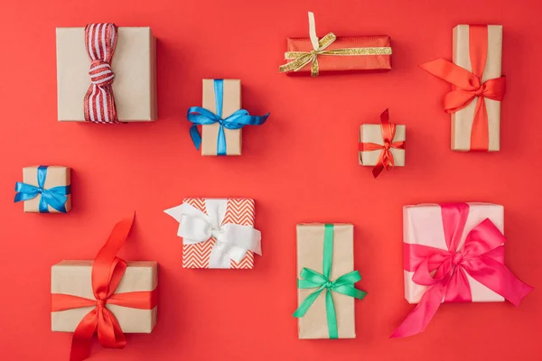 Couché plat avec arrangement de cadeaux de Noël enveloppés isolés sur rouge — Photo de stock