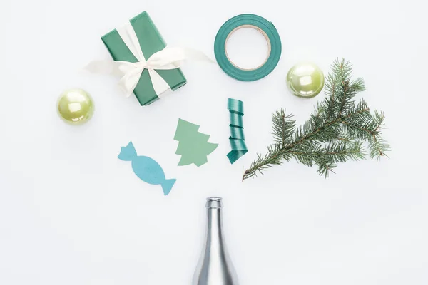 Draufsicht auf verpacktes Geschenk, silberne Flasche, Tannenzweig und Weihnachtsspielzeug isoliert auf weiß — Stockfoto