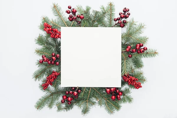 Vista superior de la corona de pino con decoraciones de Navidad y espacio en blanco cuadrado en medio aislado en blanco - foto de stock
