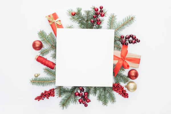 Vue de dessus des branches de pin, décorations de Noël et cadeaux avec espace vide carré au milieu isolé sur blanc — Photo de stock