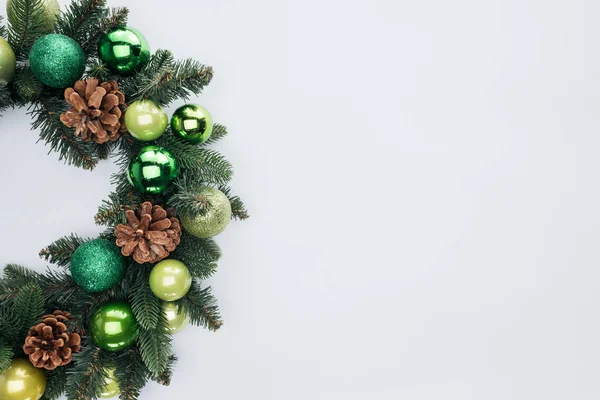 Верхний вид декоративного праздничного венка с зелеными рождественскими игрушками, изолированными на белом — стоковое фото