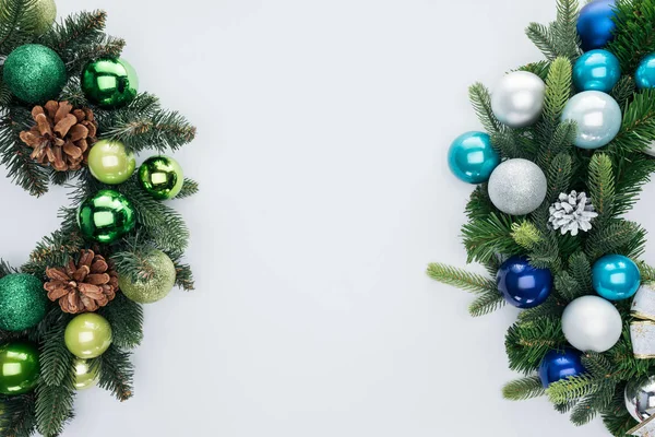 Vue de dessus des couronnes de pins avec des boules de Noël vertes, bleues et argentées isolées sur blanc — Photo de stock