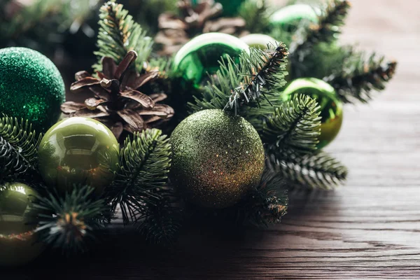 Close up view of pine tree wreath with green christmas balls on wooden background — Stock Photo