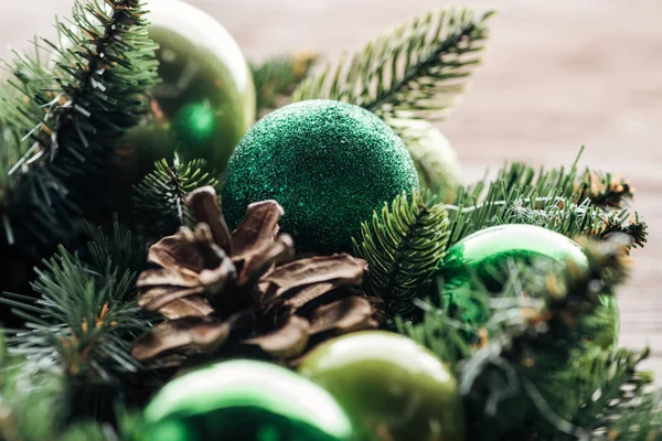 Cerca de la vista de la corona de pino con bolas de Navidad verde sobre fondo de madera - foto de stock