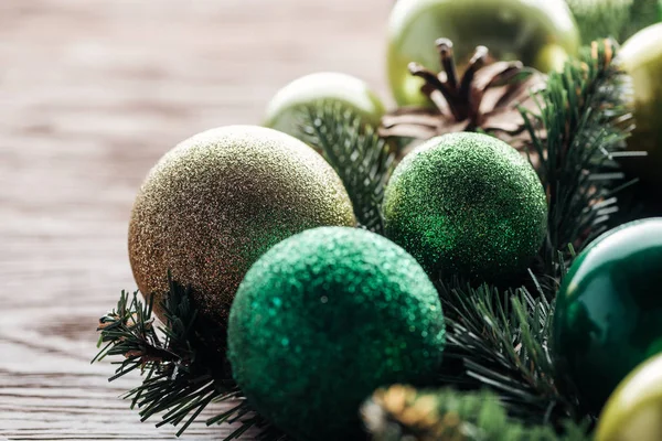 Close up view of pine tree wreath with green christmas balls on wooden background — Stock Photo