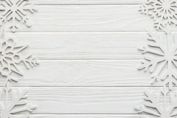 Tendido plano con copos de nieve decorativos sobre mesa de madera blanca - foto de stock