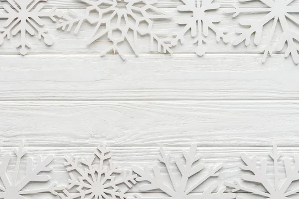 Posa piatta con fiocchi di neve decorativi su un tavolo di legno bianco — Foto stock