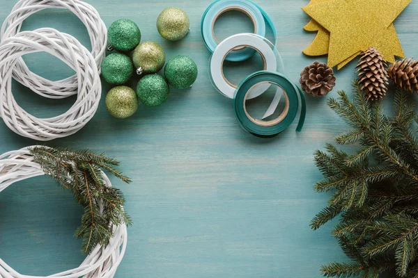 Piso con decoraciones arregladas para la corona de Navidad hecha a mano en la mesa de madera azul - foto de stock